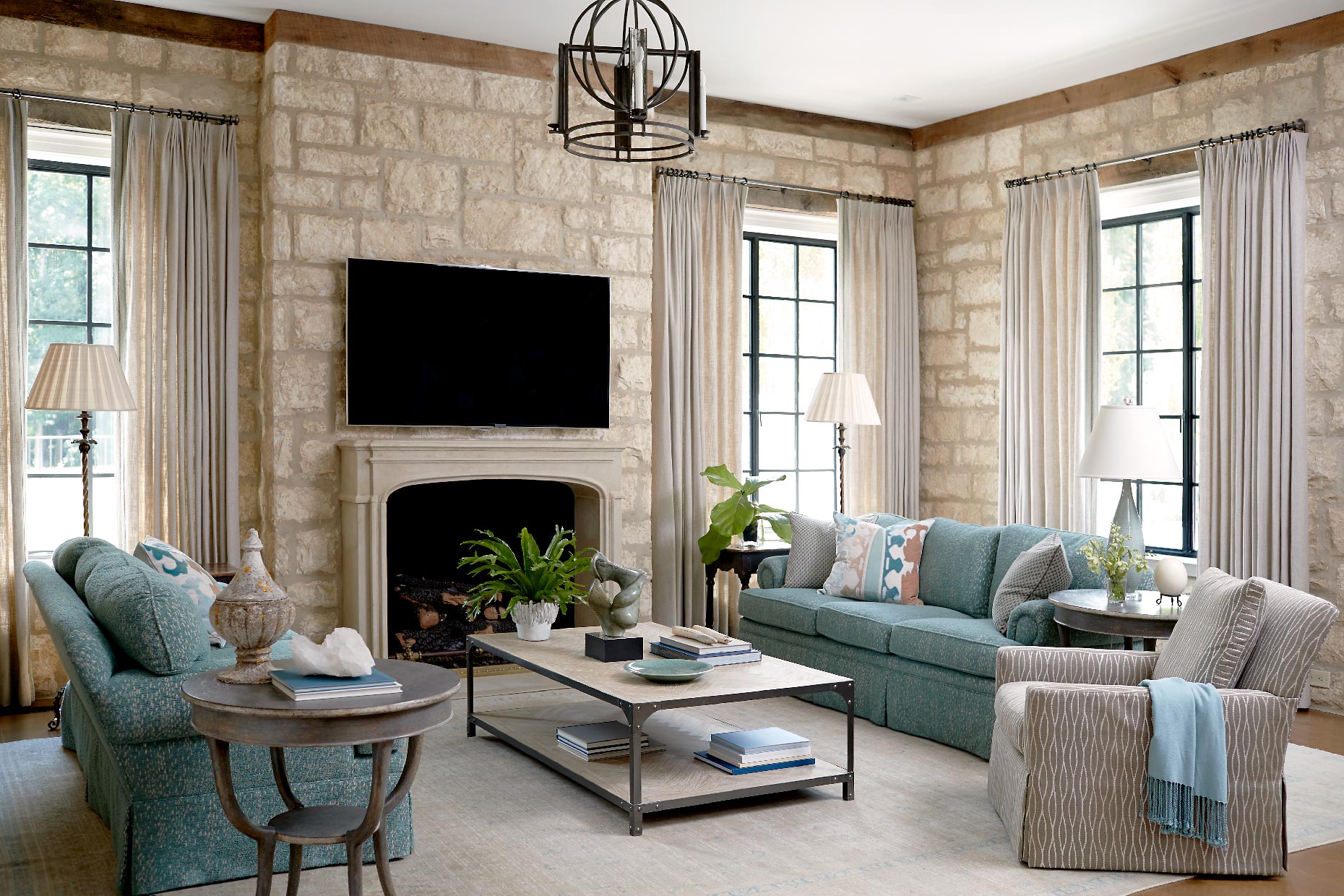 living room with tall windows and exposed stone