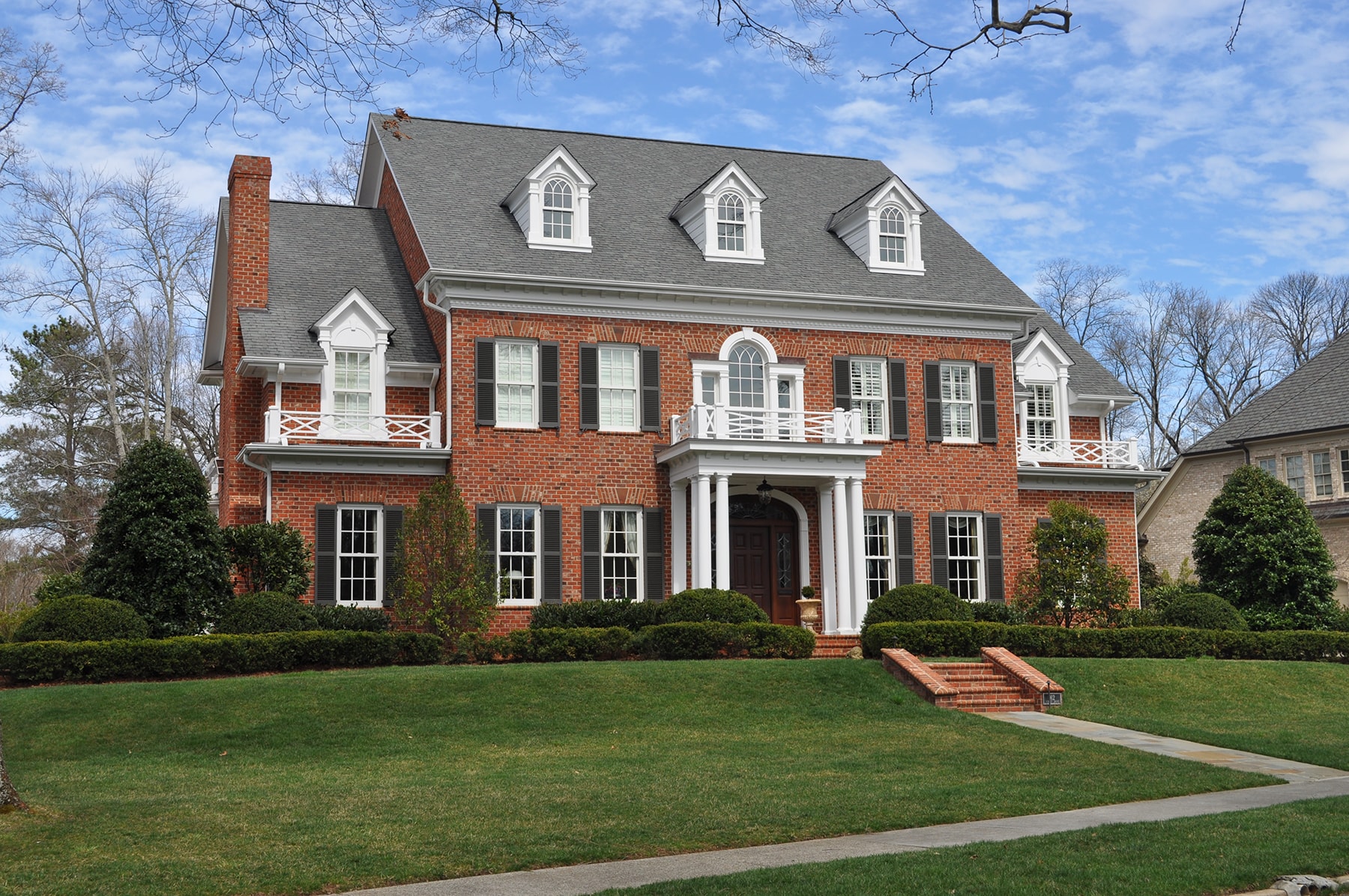 red bricked custom home with pillars